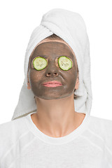 Image showing Young beautiful woman in mask for the face. therapeutic black clay. Spa treatment.