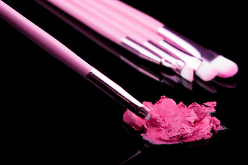 Image showing lipstick with a brush make-up on black 