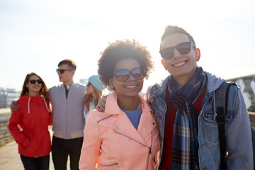 Image showing happy teenage friends in shades hugging on street