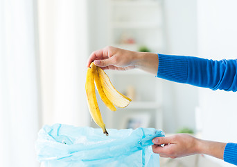 Image showing close up of hand putting food waste to rubbish bag