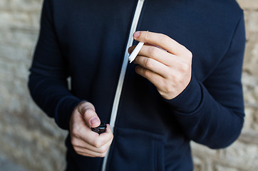 Image showing close up of addict hands with marijuana joint