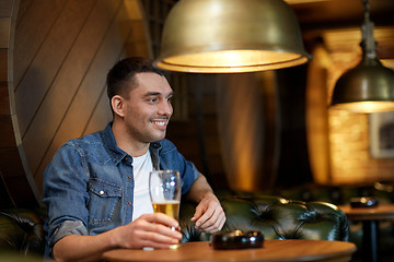 Image showing happy man drinking draft beer at bar or pub