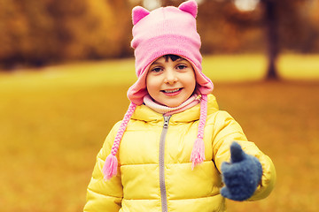 Image showing happy little girl showing thumbs up outdoors