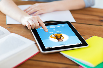 Image showing close up of student with tablet pc and notebook