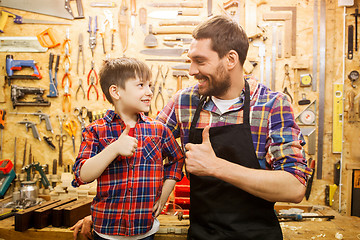 Image showing father and little son making thumbs up at workshop