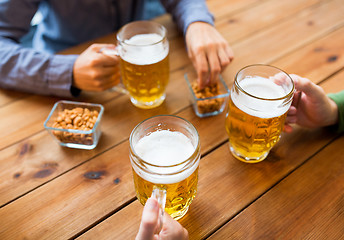 Image showing close up of hands with beer mugs at bar or pub