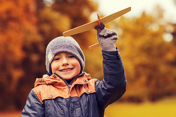 Image showing happy little boy playing with toy plane outdoors