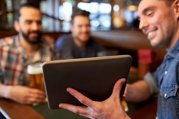 Image showing male friends with tablet pc drinking beer at bar