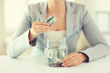 Image showing close up of woman hands and dollar money in jar