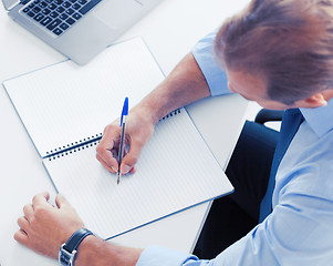 Image showing businessman writing in notebook