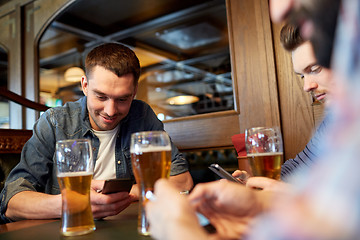 Image showing men with smartphones drinking beer at bar or pub