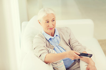 Image showing senior woman with remote watching tv at home