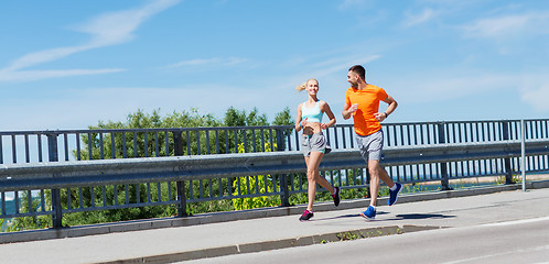 Image showing smiling couple running at summer seaside