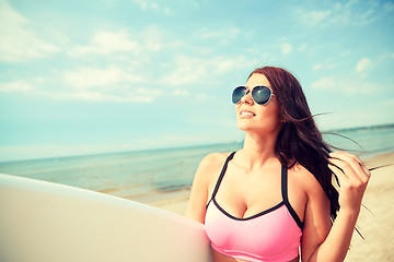 Image showing smiling young woman with surfboard on beach