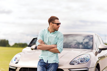 Image showing happy man standing at car outdoors