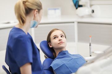 Image showing happy female dentist with patient girl at clinic