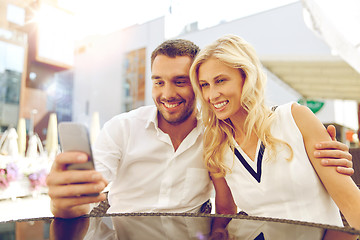 Image showing couple taking selfie with smatphone at restaurant