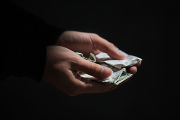 Image showing close up of addict hands with drugs and money