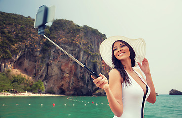 Image showing happy woman taking selfie with smartphone on beach