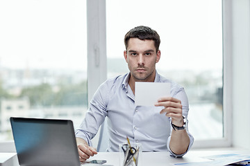 Image showing businessman showing blank paper card at office