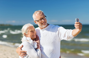 Image showing happy senior couple hugging on summer beach