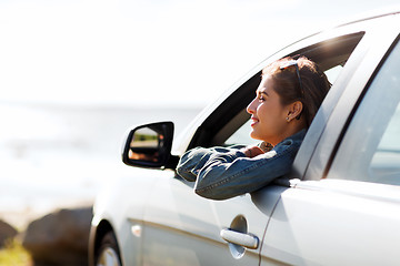 Image showing happy teenage girl or young woman in car