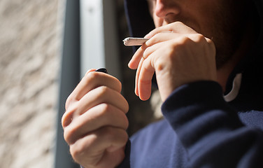 Image showing close up of addict smoking marijuana joint