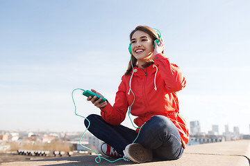 Image showing happy young woman with smartphone and headphones