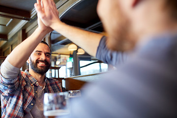 Image showing happy male friends making high five at bar or pub