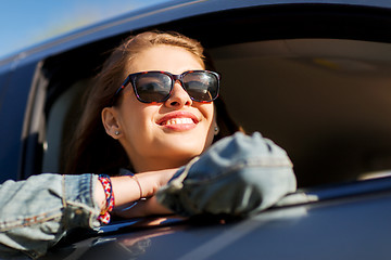 Image showing happy teenage girl or young woman in car