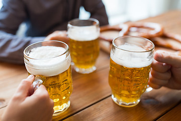 Image showing close up of hands with beer mugs at bar or pub