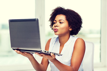 Image showing african woman sending kiss to laptop computer