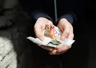 Image showing close up of addict hands with drugs and money