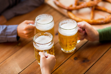 Image showing close up of hands with beer mugs at bar or pub