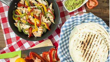 Image showing delicious wrap tortilla with spicy chicken vegetables guacamole