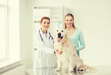 Image showing happy woman with dog and doctor at vet clinic