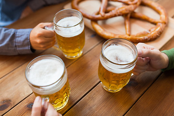 Image showing close up of hands with beer mugs at bar or pub