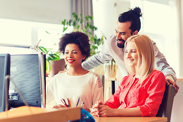 Image showing happy creative team with computer in office