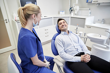 Image showing happy female dentist with man patient at clinic