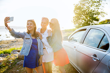 Image showing happy women taking selfie near car at seaside