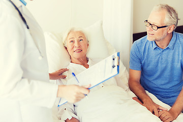 Image showing senior woman and doctor with clipboard at hospital