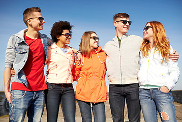 Image showing happy teenage friends in shades talking on street