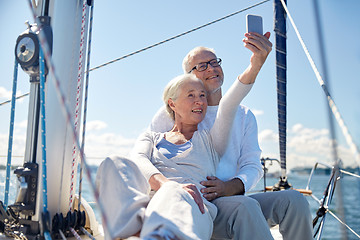 Image showing seniors with smartphone taking selfie on yacht