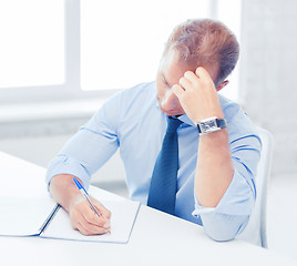 Image showing businessman with notebook and computer