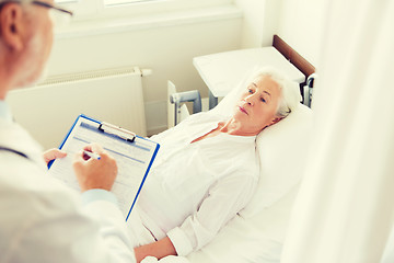 Image showing senior woman and doctor with clipboard at hospital