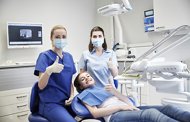 Image showing happy female dentist with patient girl at clinic