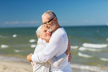 Image showing happy senior couple hugging on summer beach