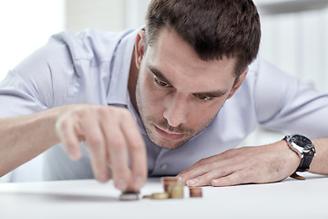 Image showing businessman with coins at office