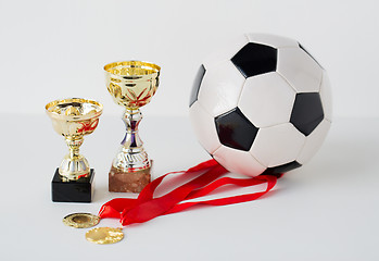 Image showing close up of football ball, golden cups and medals