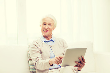 Image showing happy senior woman with tablet pc at home